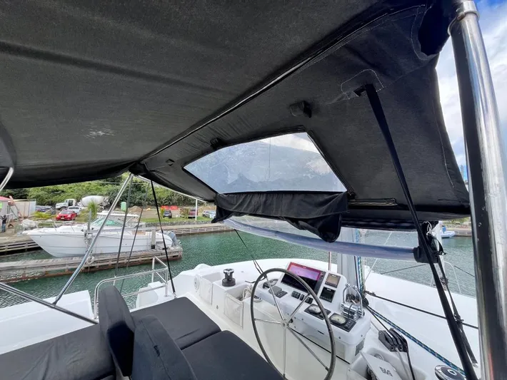 Out Of The Blue Yacht Photos Pics 2019 Lagoon 50 yacht cockpit with steering wheel, navigation equipment, and canopy.