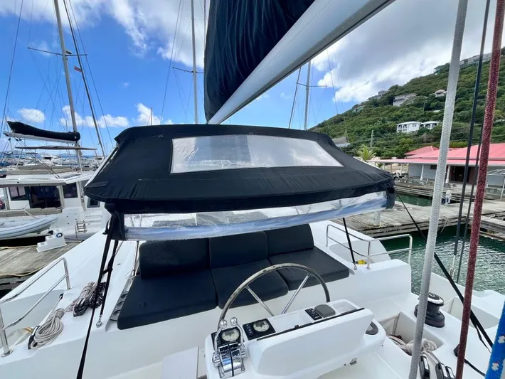 Out Of The Blue Yacht Photos Pics 2019 Lagoon 50 yacht cockpit with helm, docked at marina under blue sky.