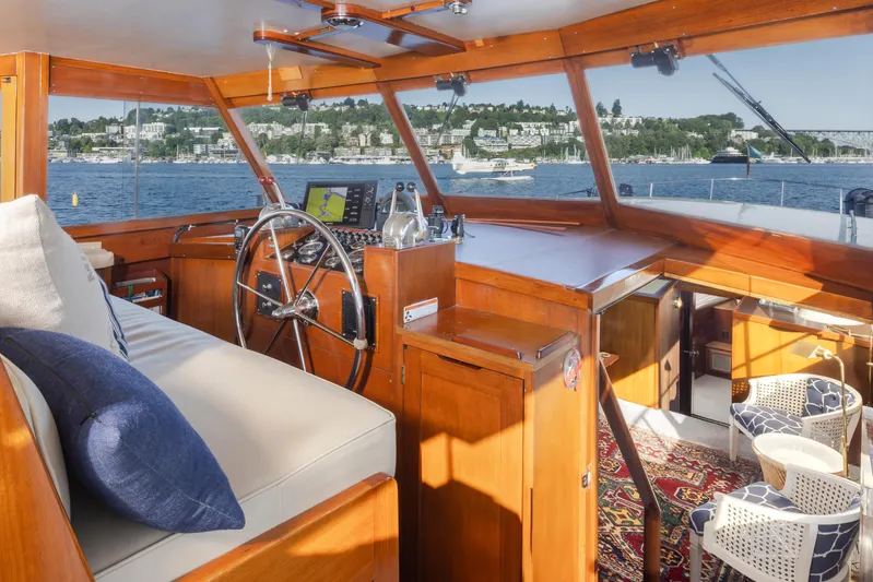 Madman Yacht Photos Pics Interior of 1965 Stephens Flushdeck yacht with wooden helm and lake view.