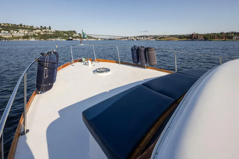 Madman Yacht Photos Pics 1965 Stephens Flushdeck yacht on calm water, scenic view of shoreline and bridge.