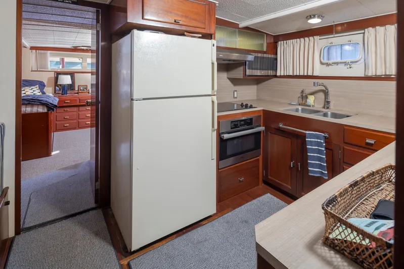 Madman Yacht Photos Pics Interior of a 1965 Stephens Flushdeck yacht kitchen with vintage appliances and wood cabinetry.