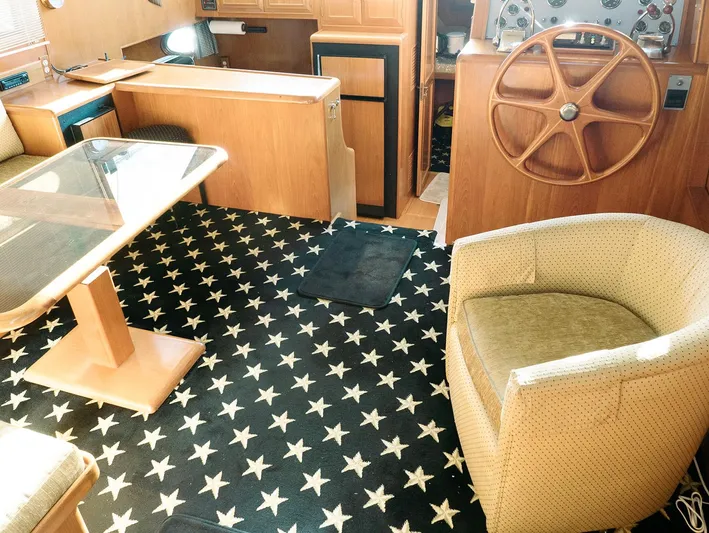 L' Espirit Yacht Photos Pics Interior of 1989 Ocean Alexander 440 CPMY yacht with star-patterned carpet and wooden furnishings.