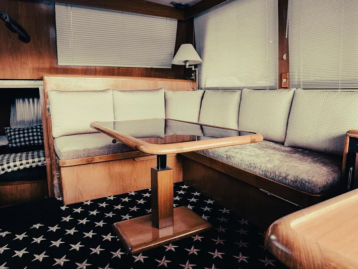 L' Espirit Yacht Photos Pics Interior of 1989 Ocean Alexander 440 CPMY yacht with cushioned seating and wooden table.