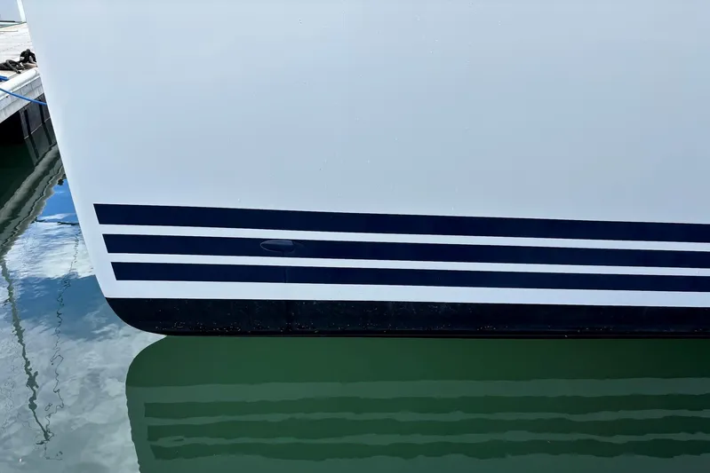 Vamoosh Yacht Photos Pics Close-up of 2012 X-Yachts XP-44 hull with sleek black stripes above waterline.