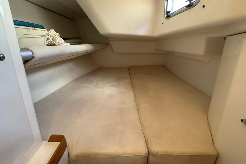 Vamoosh Yacht Photos Pics Cabin interior of 2012 X-Yachts XP-44, featuring beige cushions and a small window.
