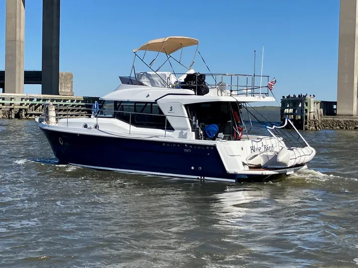 Blue Bird Yacht Photos Pics 2017 Beneteau Swift Trawler 30 navigating under a bridge on a sunny day.