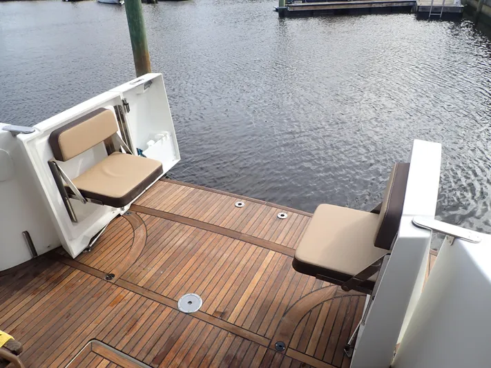 Blue Bird Yacht Photos Pics 2017 Beneteau Swift Trawler 30 with teak deck and foldable seats by the water.