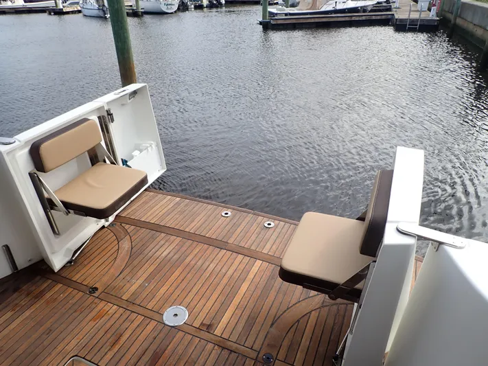 Blue Bird Yacht Photos Pics 2017 Beneteau Swift Trawler 30 deck with foldable seats, overlooking marina water.