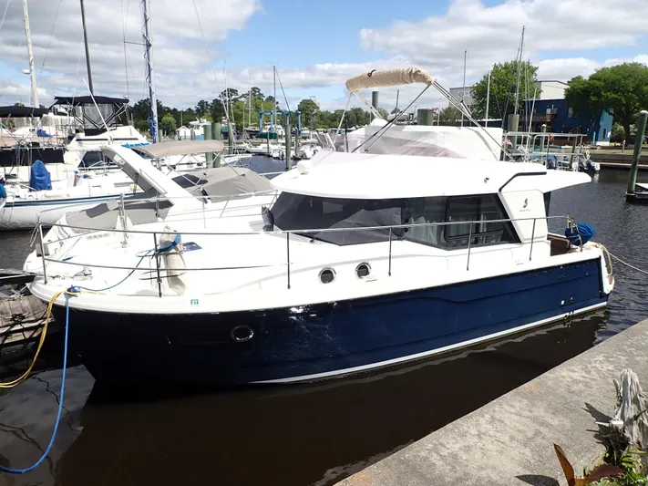 Blue Bird Yacht Photos Pics 2017 Beneteau Swift Trawler 30 docked at a marina under a partly cloudy sky.