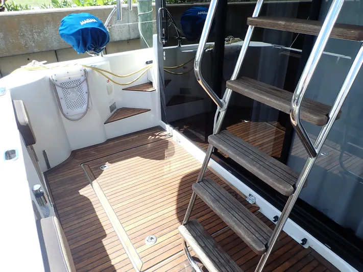 Blue Bird Yacht Photos Pics 2017 Beneteau Swift Trawler 30 deck with wooden flooring and metal ladder.