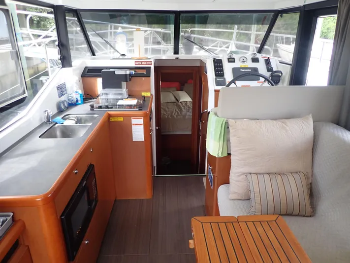 Blue Bird Yacht Photos Pics 2017 Beneteau Swift Trawler 30 interior with kitchen, seating, and helm.