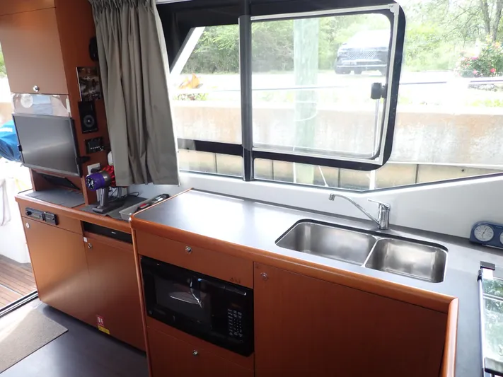 Blue Bird Yacht Photos Pics Interior of 2017 Beneteau Swift Trawler 30 kitchen with sink and microwave.