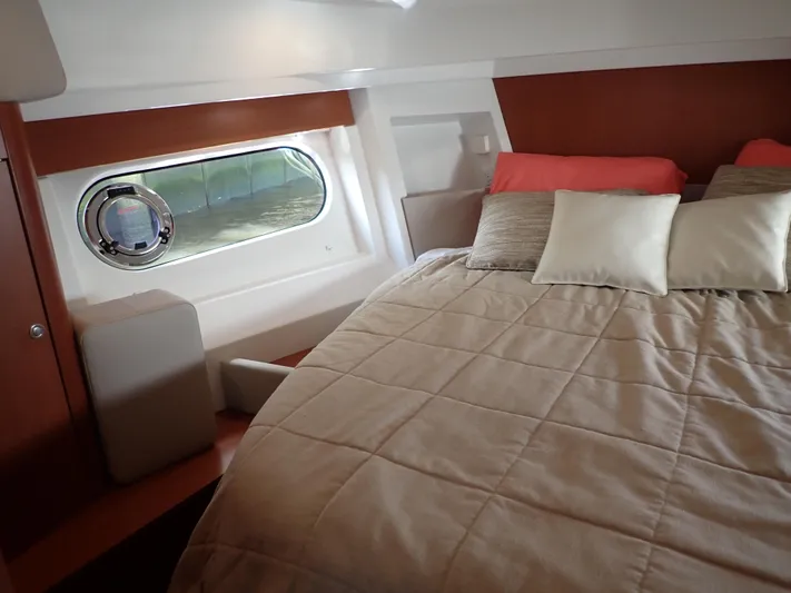 Blue Bird Yacht Photos Pics Cozy cabin interior of 2017 Beneteau Swift Trawler 30 with bed and porthole window.