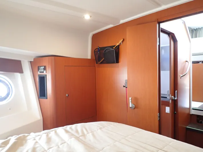 Blue Bird Yacht Photos Pics 2017 Beneteau Swift Trawler 30 cabin interior with wood paneling and porthole window.