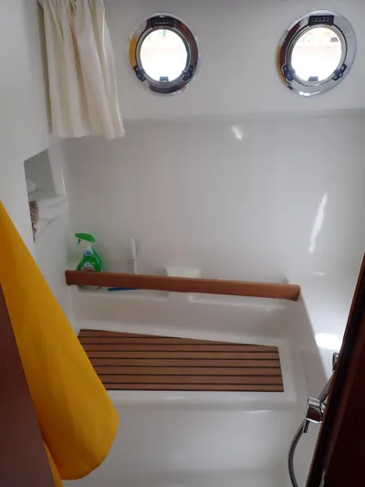 Blue Bird Yacht Photos Pics Bathroom interior of 2017 Beneteau Swift Trawler 30 with portholes and wooden accents.