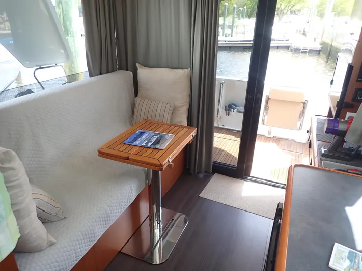 Blue Bird Yacht Photos Pics Interior of 2017 Beneteau Swift Trawler 30 with cozy seating and wooden table.