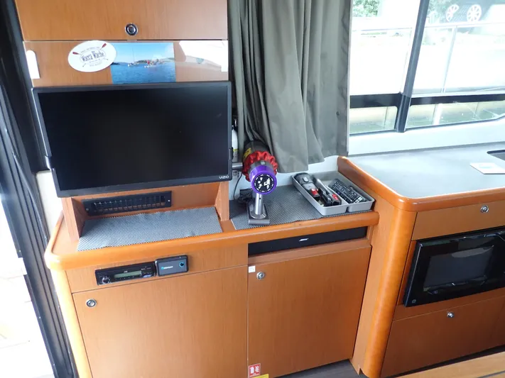 Blue Bird Yacht Photos Pics Interior of 2017 Beneteau Swift Trawler 30 with TV, vacuum, and storage cabinets.