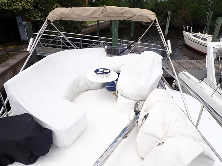 Blue Bird Yacht Photos Pics 2017 Beneteau Swift Trawler 30 flybridge with covered seating and table, docked at marina.