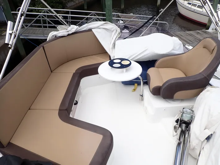 Blue Bird Yacht Photos Pics 2017 Beneteau Swift Trawler 30 deck with seating and table, docked at marina.