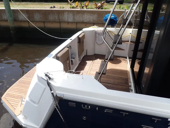 Blue Bird Yacht Photos Pics 2017 Beneteau Swift Trawler 30, rear deck view, docked, with wooden flooring and metal ladder.
