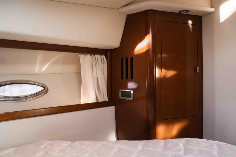  Yacht Photos Pics Interior cabin of 2008 Sea Ray 38 Sundancer yacht with wood paneling and porthole window.