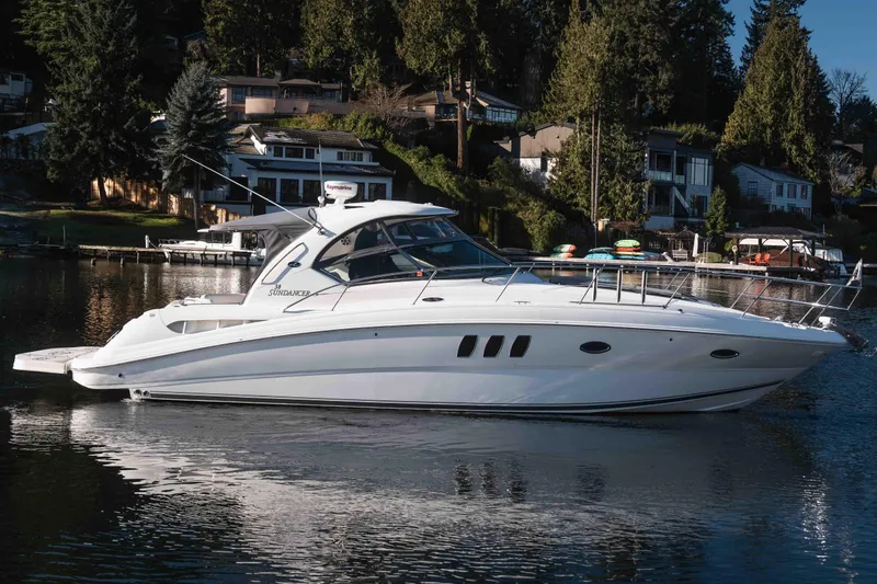  Yacht Photos Pics 2008 Sea Ray 38 Sundancer yacht on a serene lake, surrounded by lush greenery.