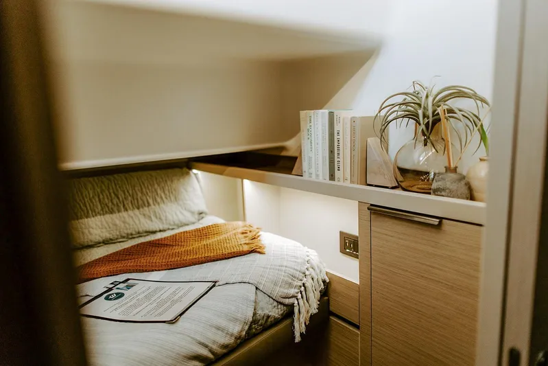 Wanderlust Yacht Photos Pics Cozy cabin interior of 2023 Lagoon 50 yacht with books and plants.