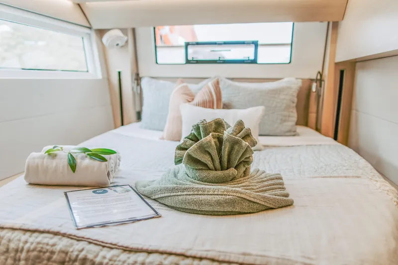 Wanderlust Yacht Photos Pics Luxurious cabin interior of 2023 Lagoon 50 yacht with elegant bedding and decor.