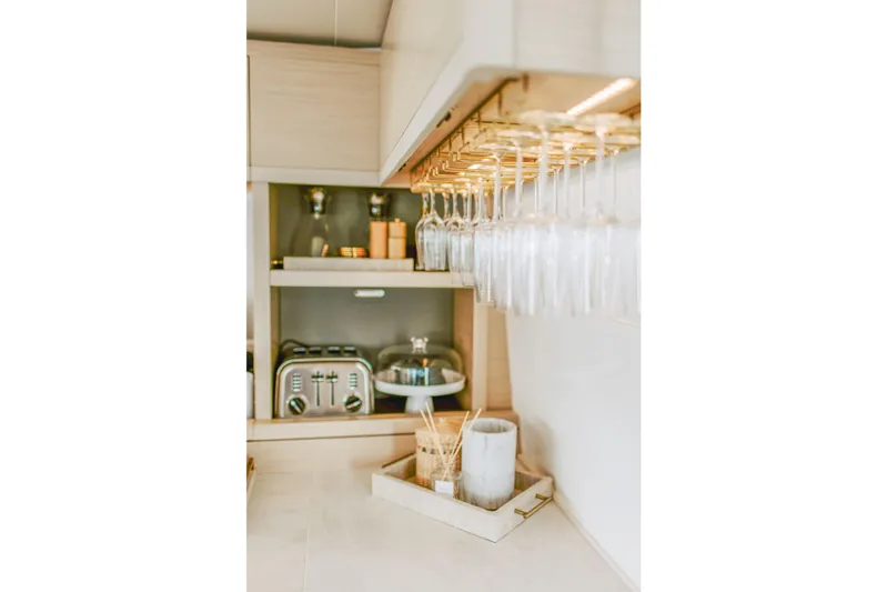 Wanderlust Yacht Photos Pics Modern kitchen interior of 2023 Lagoon 50 yacht with glassware and appliances.