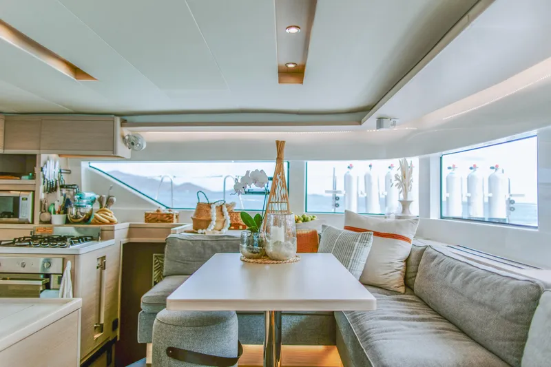 Wanderlust Yacht Photos Pics Luxurious interior of 2023 Lagoon 50 yacht with modern kitchen and cozy seating area.