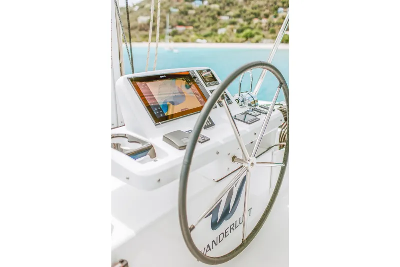 Wanderlust Yacht Photos Pics Steering wheel and navigation system on 2023 Lagoon 50 catamaran, with ocean view.