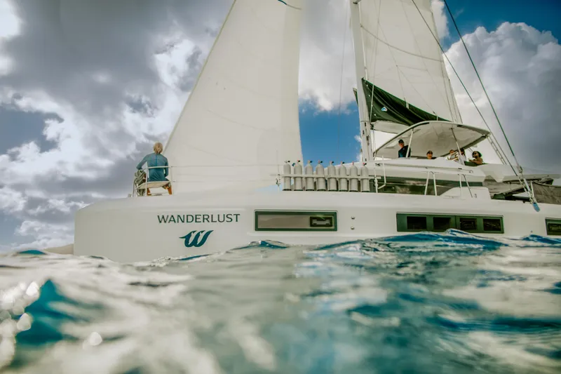 Wanderlust Yacht Photos Pics 2023 Lagoon 50 catamaran "Wanderlust" sailing on open water under cloudy skies.