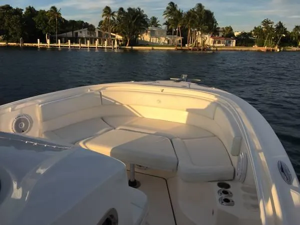  Yacht Photos Pics 2015 Edgewater 280CC boat with spacious seating, docked near palm-lined waterfront homes.