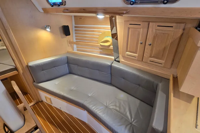 Irie Yacht Photos Pics Cozy interior of 2018 Tartan 345 sailboat with gray seating and wooden cabinetry.
