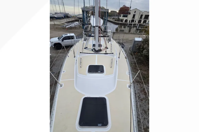 Irie Yacht Photos Pics 2018 Tartan 345 sailboat on land, viewed from deck, with nearby vehicles and buildings.