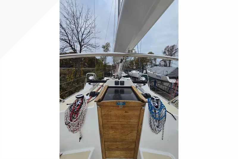 Irie Yacht Photos Pics 2018 Tartan 345 sailboat cockpit with ropes and wooden hatch, docked outdoors.