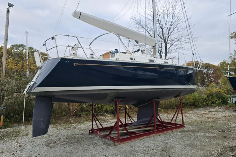 Irie Yacht Photos Pics 2018 Tartan 345 sailboat on a stand, outdoors, with trees in the background.
