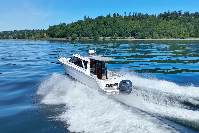 Cancelled Yacht Photos Pics 2024 Cutwater C-248 Coupe cruising on a scenic lake with lush green shoreline.