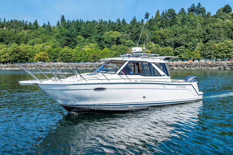 Cancelled Yacht Photos Pics 2024 Cutwater C-248 Coupe cruising on a scenic lake with lush green trees.