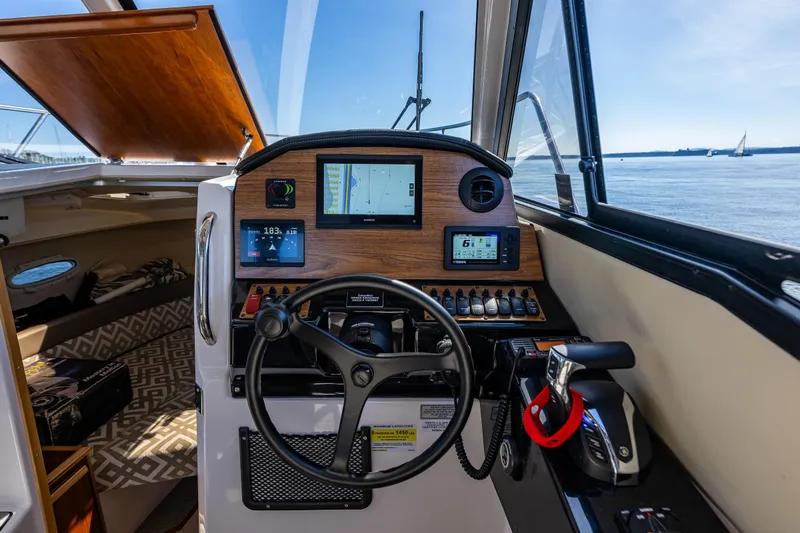 Cancelled Yacht Photos Pics 2024 Cutwater C-248 Coupe helm with navigation screens and steering wheel, overlooking serene waters.