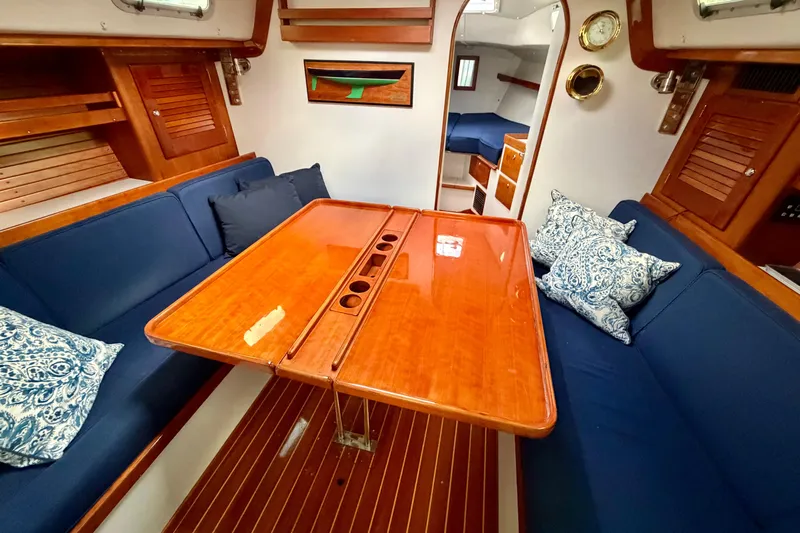 Kittywake Yacht Photos Pics Interior of 1996 J Boats J/42 sailboat with wooden table and blue seating.