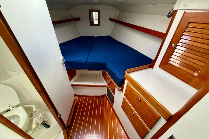 Kittywake Yacht Photos Pics 1996 J Boats J/42 cabin interior with blue bedding and wooden cabinetry.