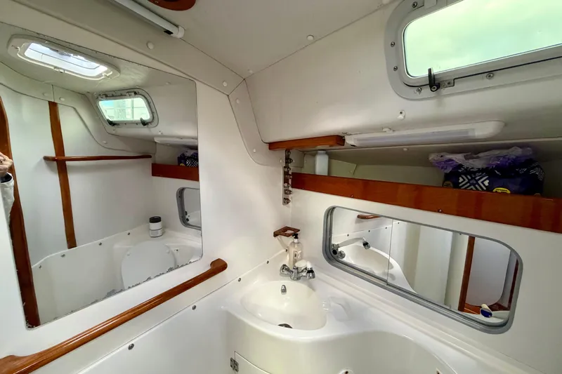 Kittywake Yacht Photos Pics Interior of 1996 J Boats J/42 sailboat bathroom with sink, mirror, and portholes.