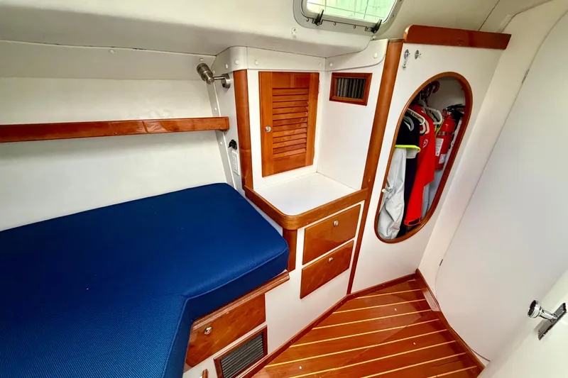Kittywake Yacht Photos Pics Cozy cabin interior of 1996 J Boats J/42 with blue bedding and wooden accents.