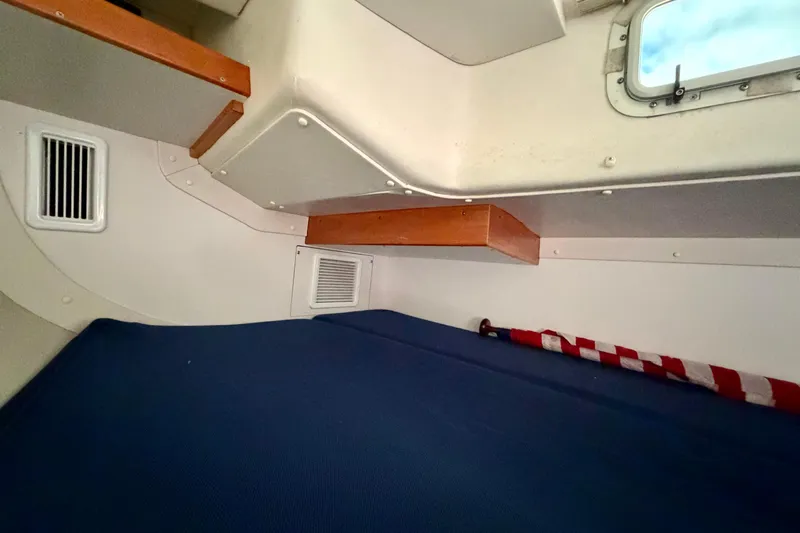 Kittywake Yacht Photos Pics Interior cabin of a 1996 J Boats J/42 sailboat with blue bedding and wooden accents.
