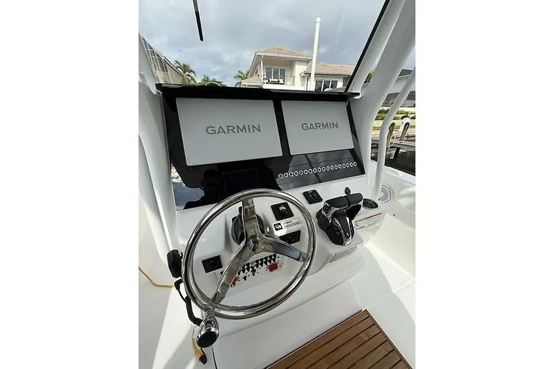  Yacht Photos Pics 2022 Edgewater 262CC boat dashboard with dual Garmin displays and steering wheel.