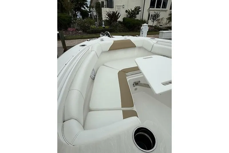  Yacht Photos Pics 2022 Edgewater 262CC boat interior with white and tan seating, featuring a table and cup holder.