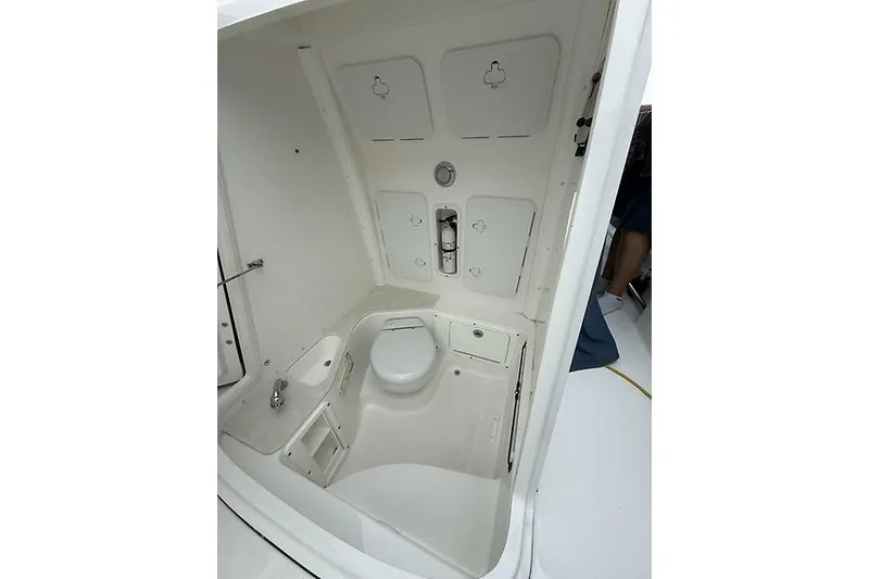  Yacht Photos Pics 2022 Edgewater 262CC boat interior with compact marine toilet and sink.