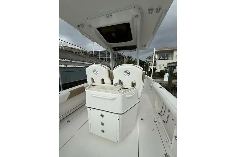  Yacht Photos Pics 2022 Edgewater 262CC boat interior with dual seats and storage, docked near waterfront homes.