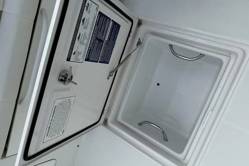  Yacht Photos Pics Open storage compartment on 2022 Edgewater 262CC boat, featuring stainless steel handles.